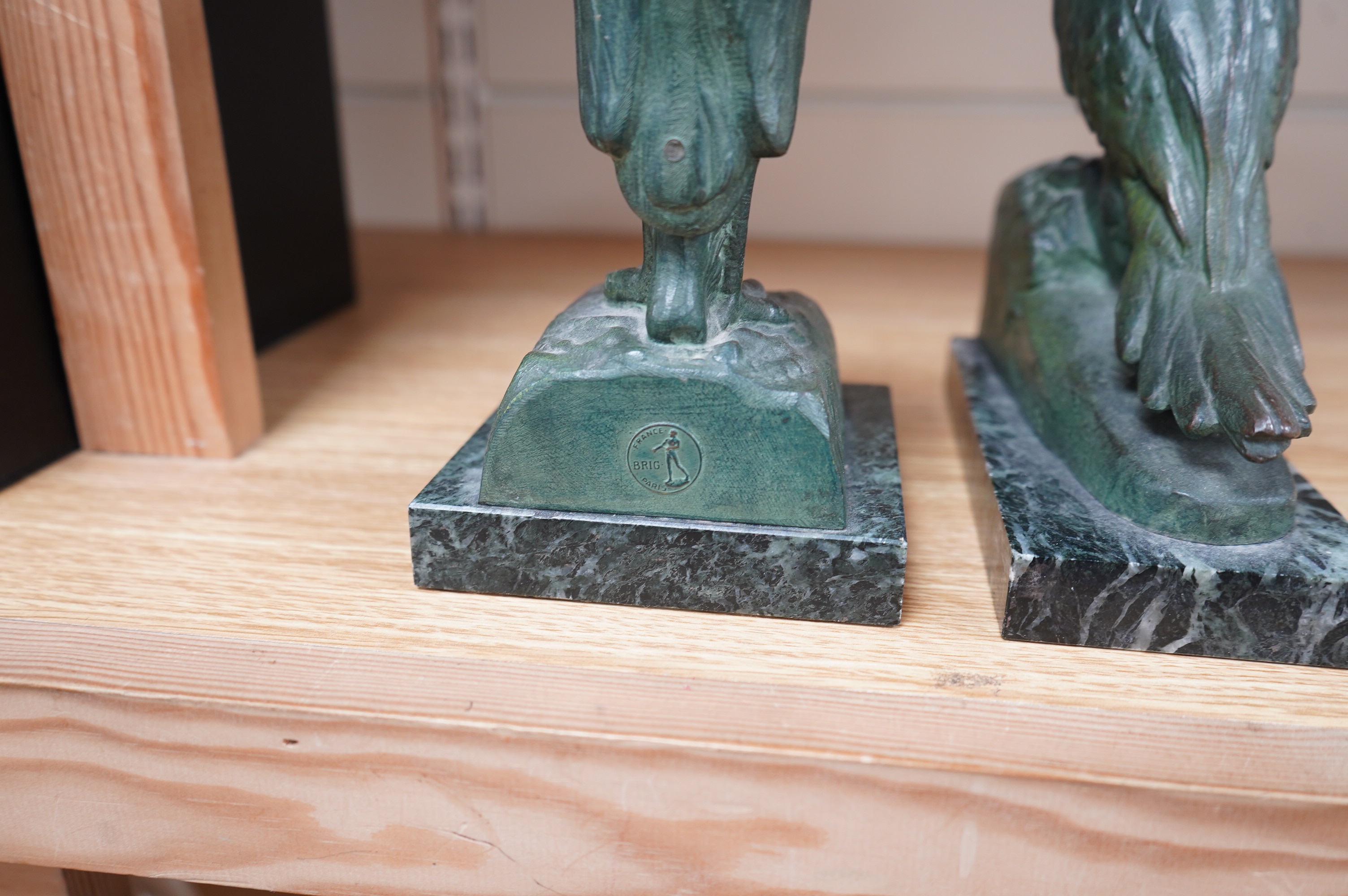 Georges Van de Voorde (Belgian 1878-1970). A pair of Art Deco bronzed spelter bookends modelled as a parrot and stork, on marble plinths, tallest 21.5cm. Condition - fair to good.